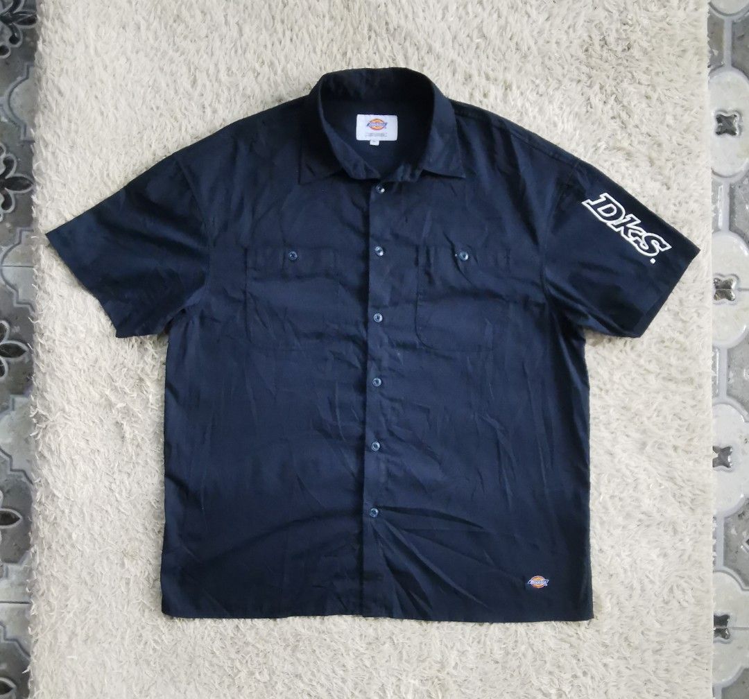 Dickies Short Sleeve Button Down Work Shirt Navy Blue (Category: Tshirts & Polo Shirts ) located in Davao. Submitted by dmp1993 (Listing ID 1465692856, Image 1). Description: Dark navy blue Dickies short sleeve button down shirt. Big bold Dickies graphic printed on the back. DKS text logo printed on the left sleeve. Two buttoned chest pockets on the front. Classic collar style with dark buttons down the front. Small Dickies tag near the bottom he