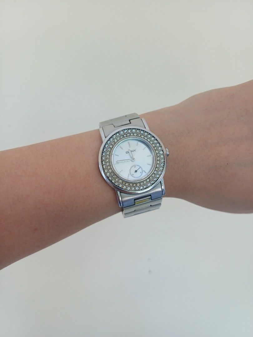 DKNY silver crystal bezel quartz wristwatch (Category: Women's Watches) located in Antipolo. Submitted by momprelovedpage (Listing ID 1465604080, Image 1). Description: - Brand: DKNY - Color: Silver - Design: Round face with subdial and crystal stones on the bezel - Material: Stainless steel link bracelet with clasp closure - Features: Battery-powered analog display, engraved logo on the back clasp - Style: Classic everyday accessory with a touch