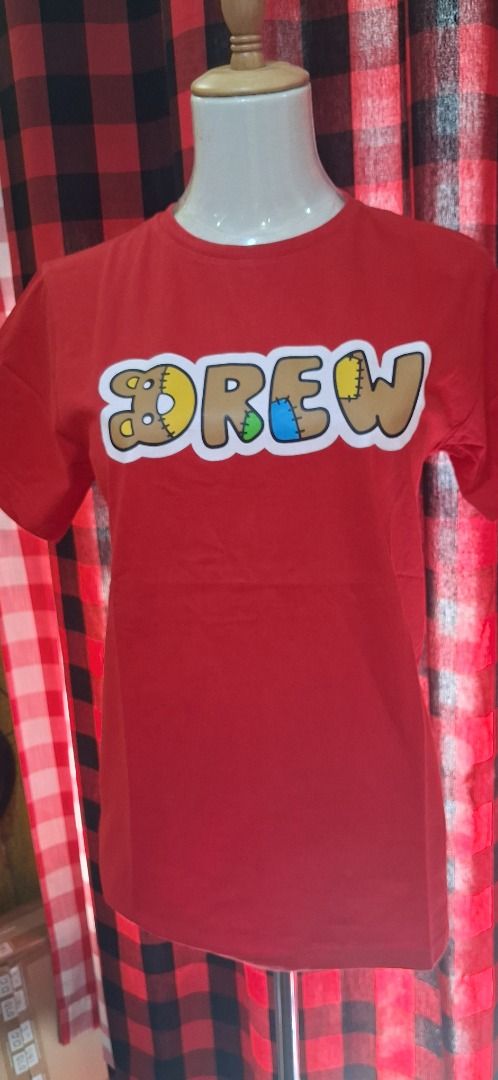 Drew House Red Graphic Tee Size S (Category: Tshirts & Polo Shirts ) located in Manila. Submitted by katkween23 (Listing ID 1465638076, Image 2). Description: - Brand: Drew House - Color: Red - Size: Small - Condition: Brand new, still sealed in original packaging with smiley sticker - Design: Bold textured DREW logo on chest - Fit/Feel: Short sleeves, crew neck, soft and comfortable fabric - Style: Casual streetwear.