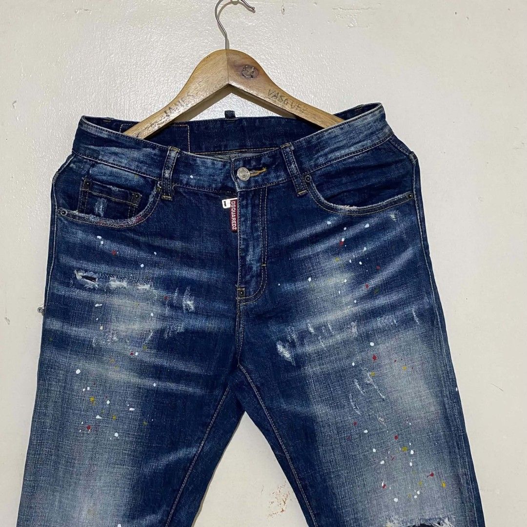 DSQUARED2 PAINT SPLATTER SLIM JEANS (Category: Jeans) located in Manila. Submitted by jiiiiiiiiiims (Listing ID 1465691768, Image 2). Description: - Brand: DSquared2 - Style: Slim fit denim jeans / Streetwear - Color/Wash: Dark blue wash with paint splatter details - Condition/Details: Distressed look with a knee rip - Size: Waist 31-32 - Origin: Made in Italy - Features: Classic button fly closure, iconic branded tag on fly, and leather patch on