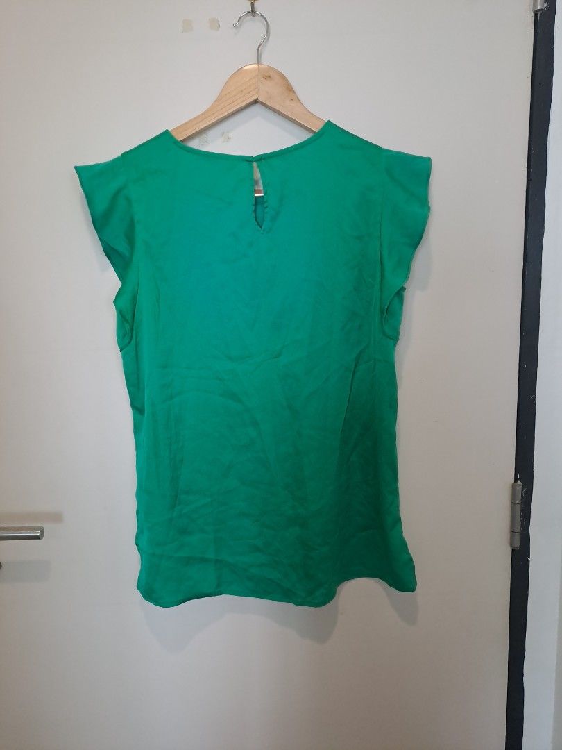 Emerald green sleeveless (Category: Sleeveless) located in Manila. Submitted by joanbalde39643 (Listing ID 1465671065, Image 3). Description: The image displays a vibrant emerald green flutter-sleeve blouse with a central column pleat, a rounded crew neckline, and a lightweight, fluid woven texture..