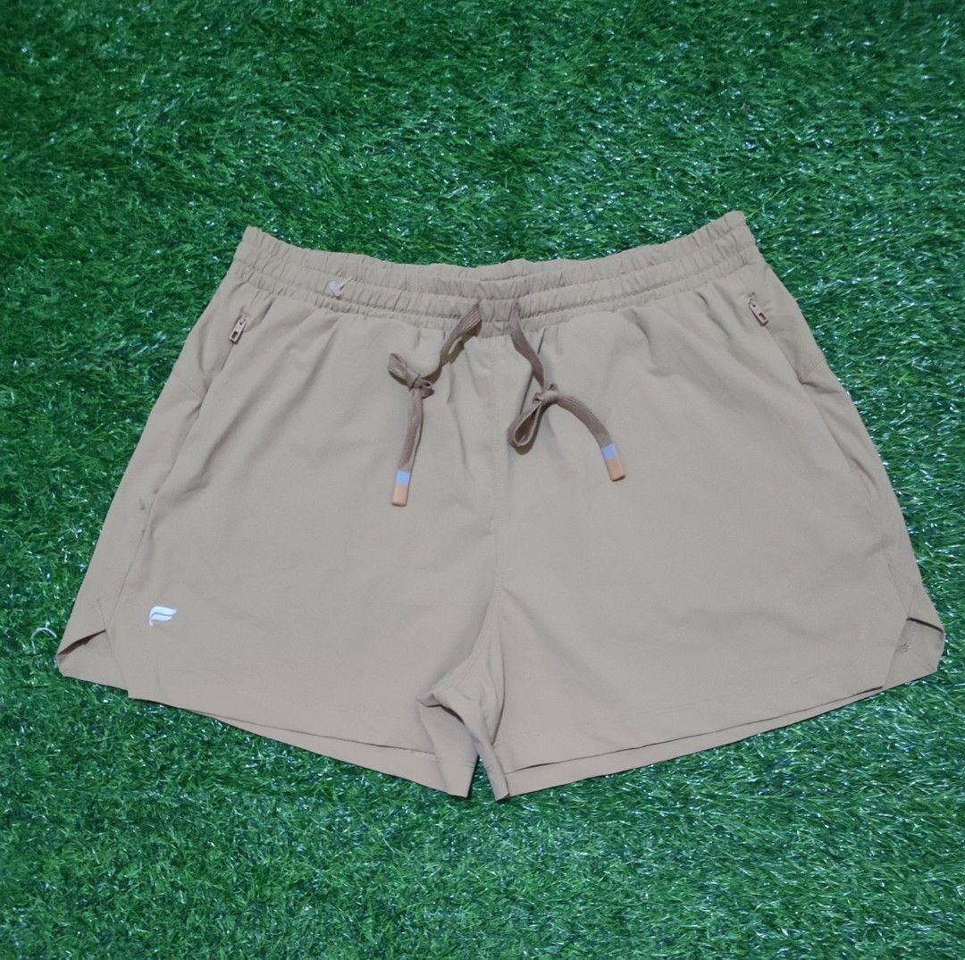 Fabletics Athletic Shorts Men (Category: Activewear) located in Cebu City. Submitted by deadjay84 (Listing ID 1465686224, Image 1). Description: - Brand: Fabletics - Color: Tan/khaki - Size: L (Tag attached) - Material: Body (79% nylon, 21% elastane), Contrast (100% polyester) - Features: Elastic waistband with adjustable dipped-tip drawstring - Pockets: Two secure side zipper pockets - Details: Small reflective logo on leg hem - Fit: Measures ap