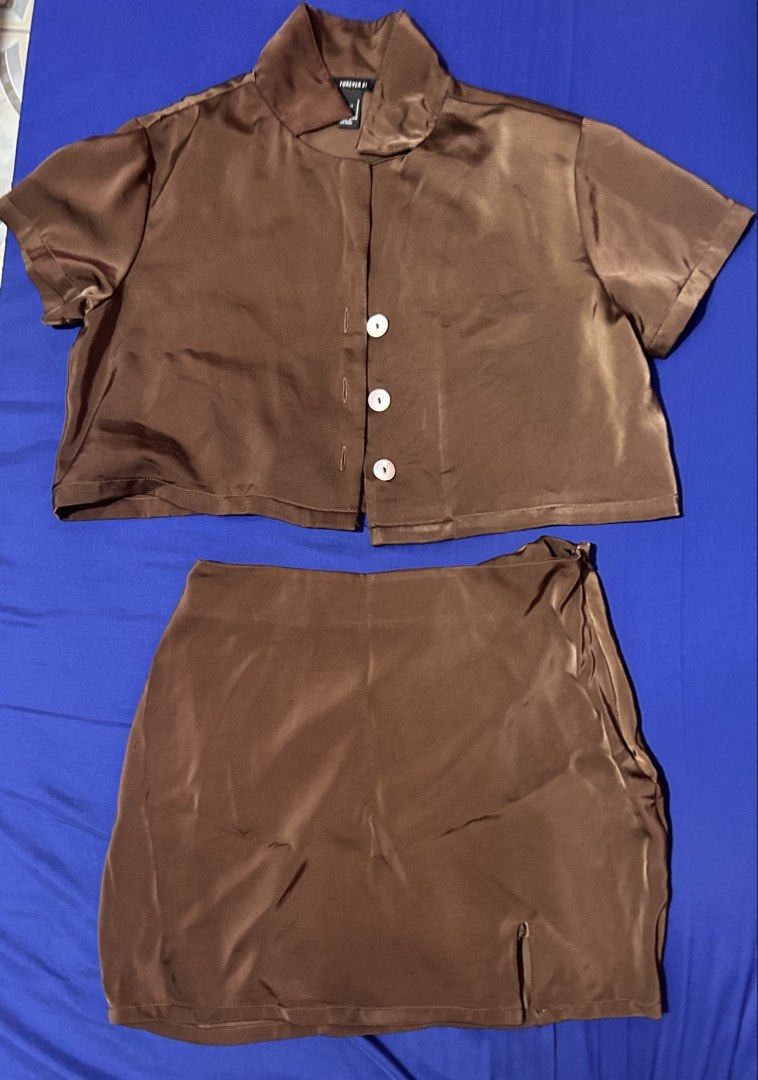 Forever 21 Brown Satin Coordinates (Category: Sets or Coordinates) located in Silang. Submitted by wearchiangmai__ (Listing ID 1465647002, Image 1). Description: - Brand: Forever 21 - Set includes: Short-sleeve button-up top and mini skirt with side slit - Material: Silky smooth brown satin - Details: Chic pearl-style buttons - Size: S (both pieces) - Condition: Great, perfect outfit for outings and dates.