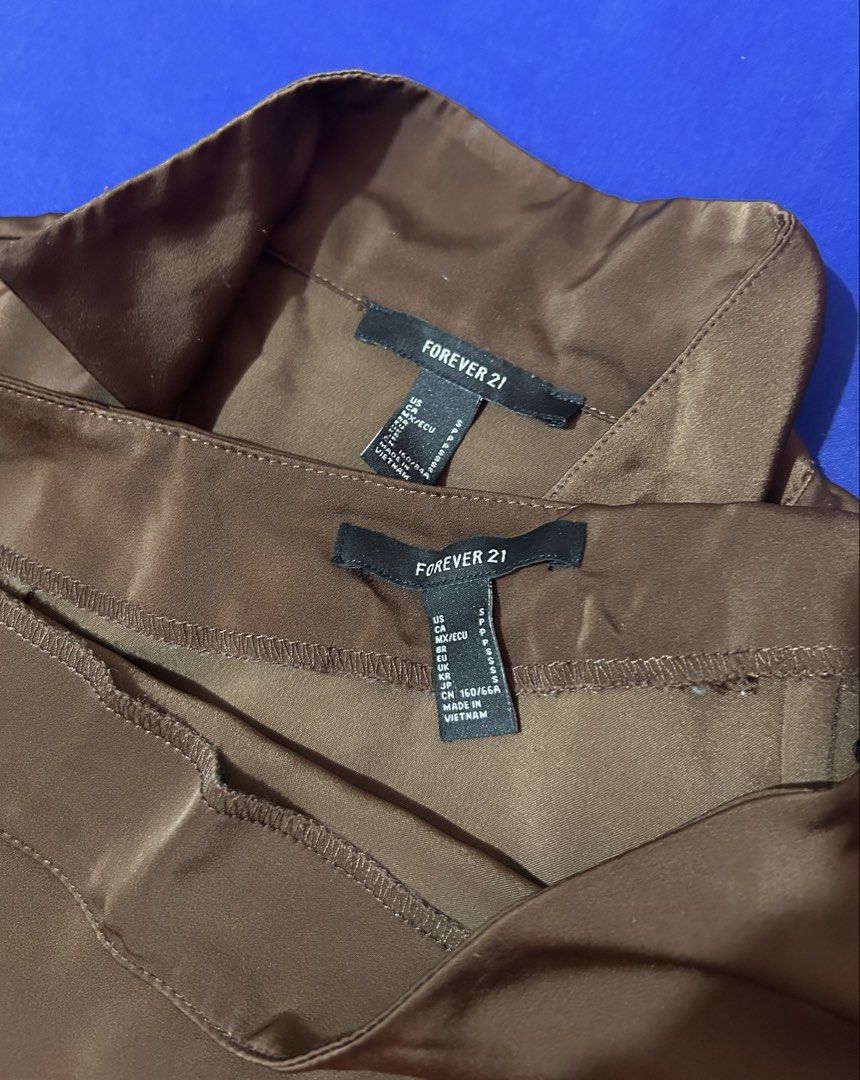 Forever 21 Brown Satin Coordinates (Category: Sets or Coordinates) located in Silang. Submitted by wearchiangmai__ (Listing ID 1465647002, Image 2). Description: - Brand: Forever 21 - Set includes: Short-sleeve button-up top and mini skirt with side slit - Material: Silky smooth brown satin - Details: Chic pearl-style buttons - Size: S (both pieces) - Condition: Great, perfect outfit for outings and dates.