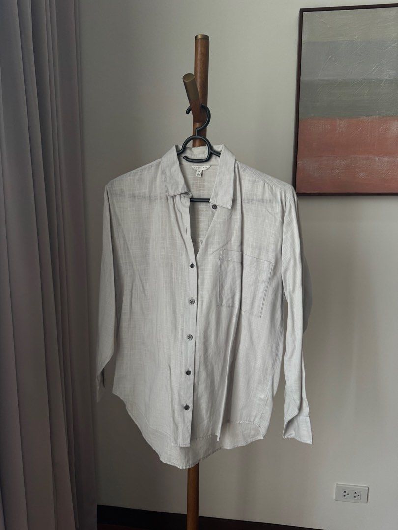 Forever 21 Light Grey Long Sleeve Button-Up (Category: Longsleeves) located in Pasig City. Submitted by kutleyn (Listing ID 1465656589, Image 1). Description: - Brand: I Love H81 - Color: Light grey with dark buttons - Style: Long sleeve button-up with classic collar and front pocket - Fabric: Textured material - Size: S - Condition: Clean and ready to wear.