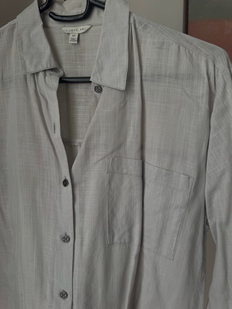 Forever 21 Light Grey Long Sleeve Button-Up (Category: Longsleeves) located in Pasig City. Submitted by kutleyn (Listing ID 1465656589, Image 3). Description: - Brand: I Love H81 - Color: Light grey with dark buttons - Style: Long sleeve button-up with classic collar and front pocket - Fabric: Textured material - Size: S - Condition: Clean and ready to wear.