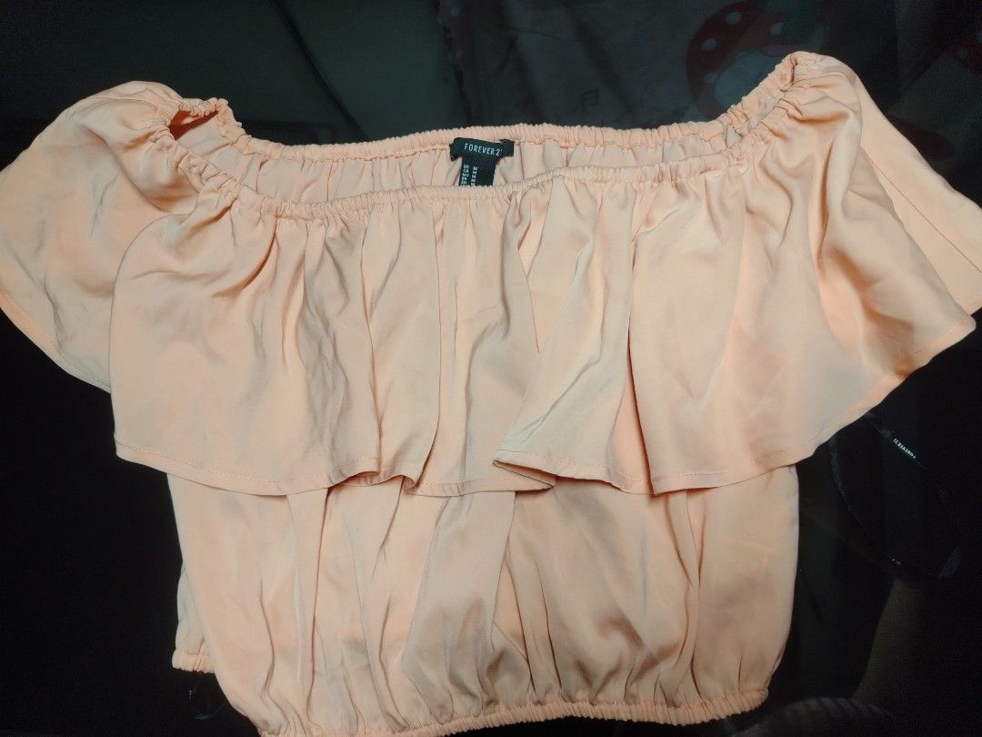 Forever 21 Peach Off-Shoulder Ruffle Crop Top Size M (Category: Sleeveless) located in Manila. Submitted by silver.springs (Listing ID 1465681636, Image 1). Description: - Brand: Forever 21 - Size: M / Stretchable free size - Color: Peach - Style: Off-shoulder crop top with a dramatic front ruffle layer - Fit: Elasticated neckline and hem for comfort - Fabric: Silky textured material, ideal for warm weather - Pairing: Great with high-waisted jean