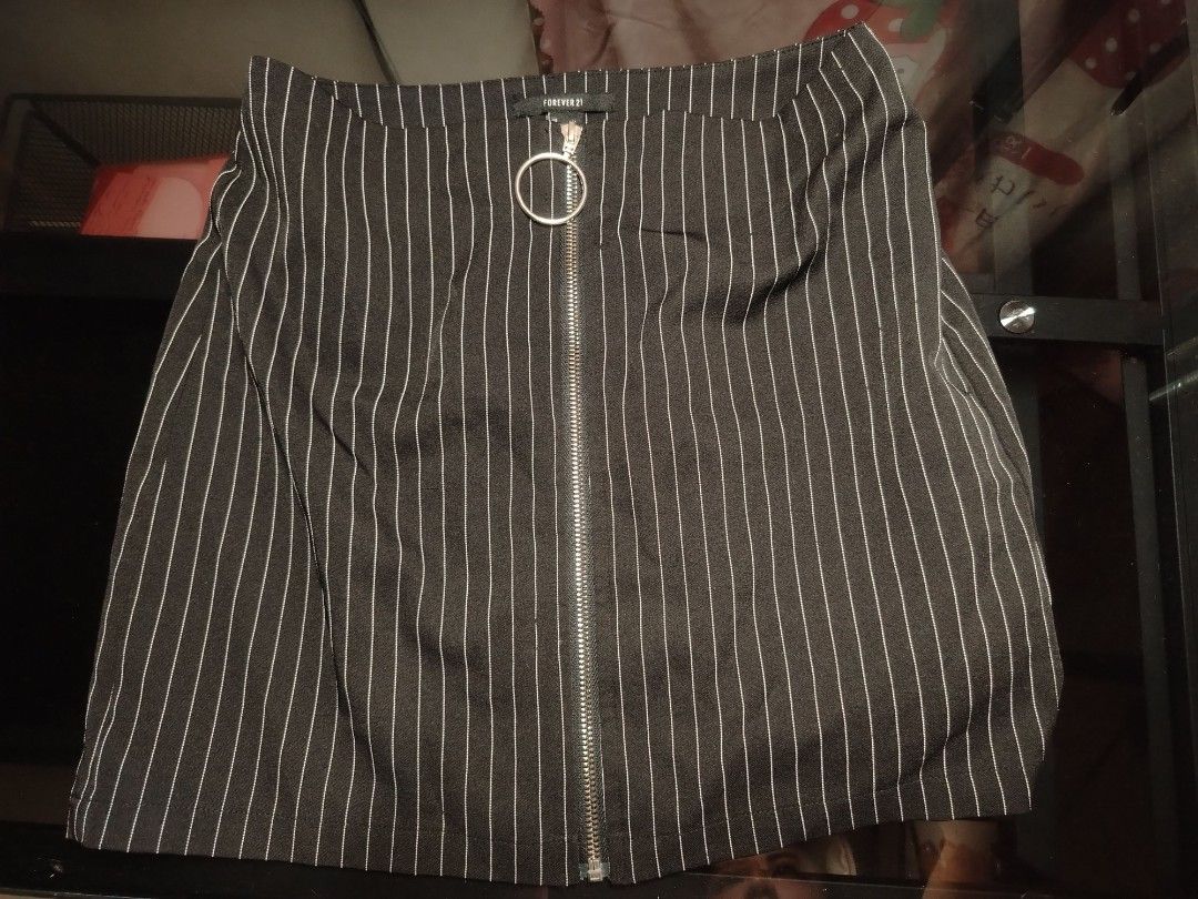 Forever 21 Pinstripe Skirt with Zip O-Ring (Category: Skirts) located in Manila. Submitted by silver.springs (Listing ID 1465681432, Image 1). Description: - Brand: Forever 21 - Design: Classic black with white pinstripes and full front silver zipper with a round O-ring pull - Fit & Fabric: Structured fabric with a flat, flattering waistband - Styling: Perfect to pair with basic tees, tanks, or cute crop tops - Condition: Excellent, ready to wear
