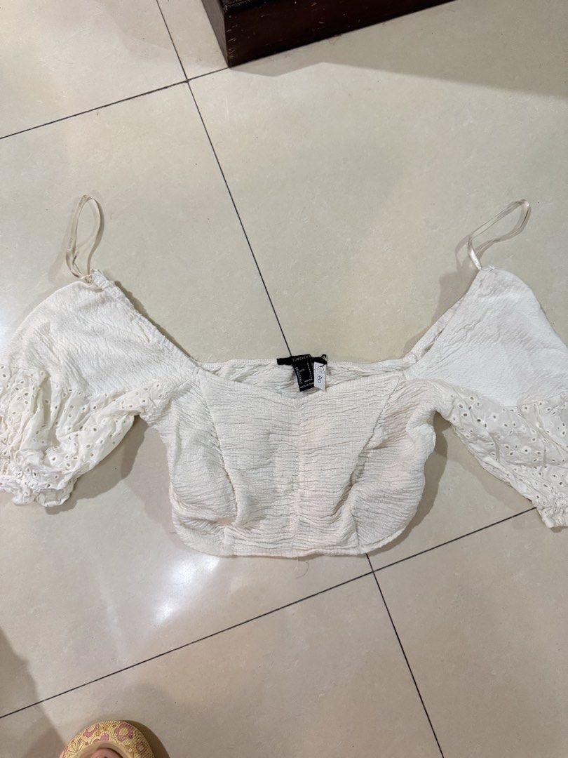 Forever 21 White Off-Shoulder Crop Top (Category: Blouses) located in Quezon City. Submitted by sweetlyluxe (Listing ID 1465622363, Image 1). Description: - Brand: Forever 21 - Size: S - Color: White - Style: Off-shoulder crop top with short, fitted cut - Details: Textured fabric, eyelet lace puff sleeves, and delicate straps - Perfect for: Warm weather and casual outings - park, garden, whimsy, girly, brandy melville, isa the label, phia.