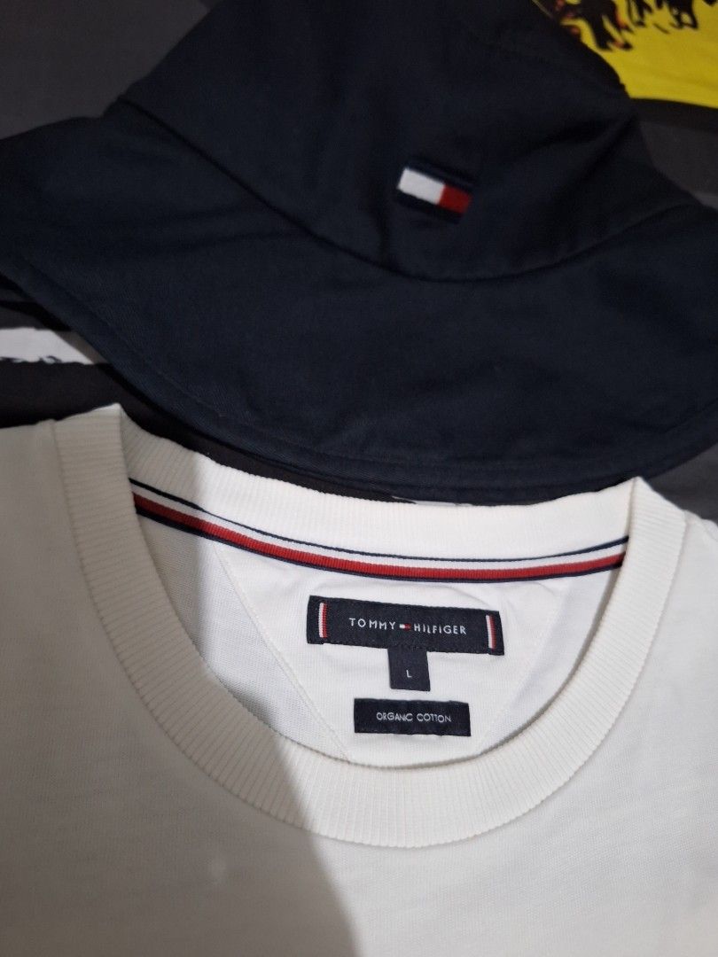 Forsale aspack tshirt size large (Category: Tshirts & Polo Shirts ) located in Manila. Submitted by adolphreyes645 (Listing ID 1465582278, Image 2). Description: - Brand: Tommy Hilfiger - Set includes: White organic cotton t-shirt and dark navy blue bucket hat - Size: L (T-shirt) - Details: Gold embroidered flag logo on the chest, iconic flag logo tag on the hat - Condition: Clean fabric with solid stitching - Style: Classic streetwear, perfect f