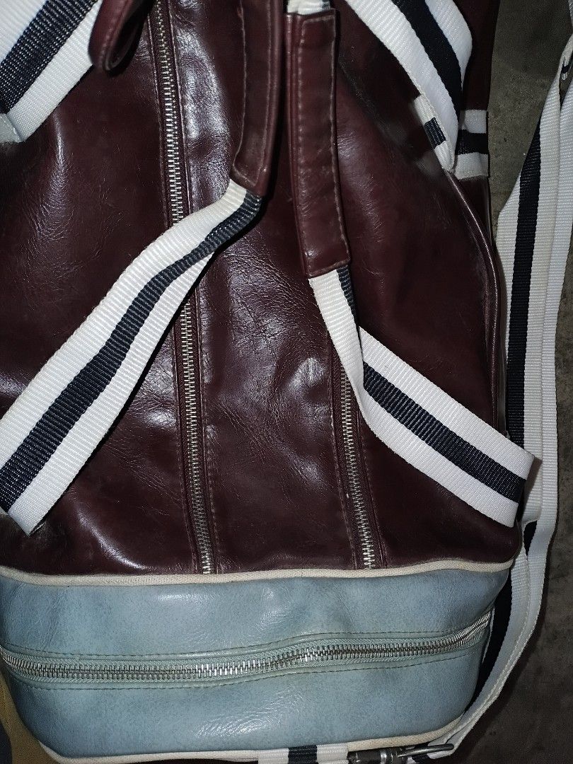 Fred Perry Barrel Duffle Bag Maroon (Category: Luxury Bags & Wallets) located in Quezon City. Submitted by bido01 (Listing ID 1465622417, Image 3). Description: - Authentic Fred Perry barrel duffle bag - Colorway: Maroon, cream, and light blue end panel - Features large bold branding and "Original Since 1952" print - Striped webbing carry handles and adjustable shoulder strap - Top zipper closure with a lined interior and brand tag - Condition: M