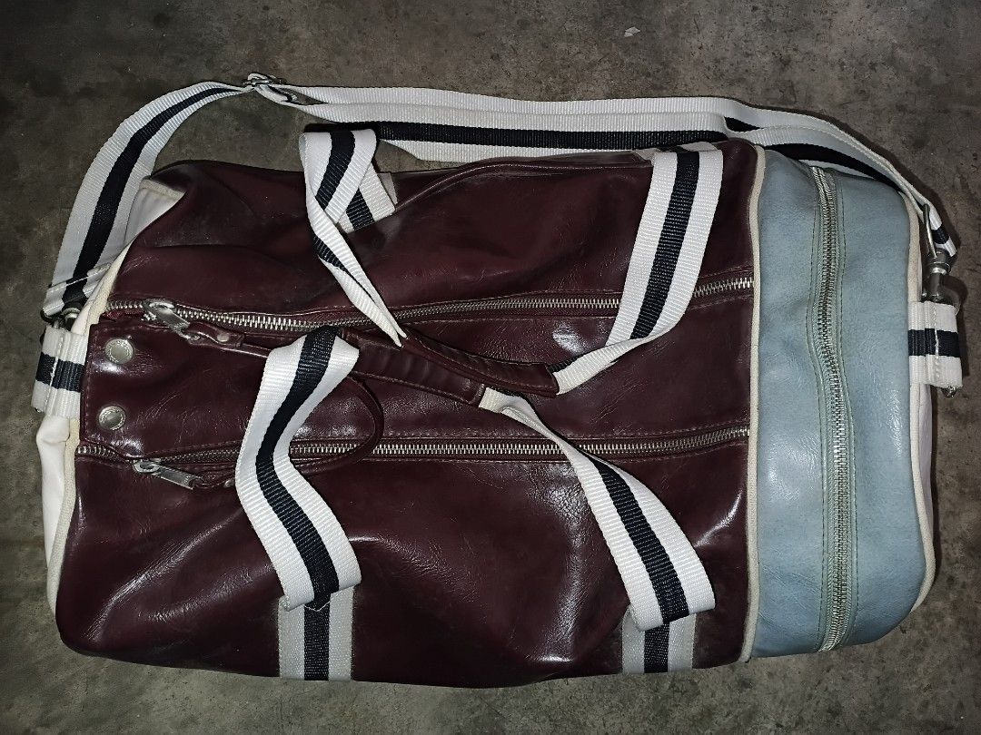 Fred Perry Barrel Duffle Bag Maroon (Category: Luxury Bags & Wallets) located in Quezon City. Submitted by bido01 (Listing ID 1465622417, Image 2). Description: - Authentic Fred Perry barrel duffle bag - Colorway: Maroon, cream, and light blue end panel - Features large bold branding and "Original Since 1952" print - Striped webbing carry handles and adjustable shoulder strap - Top zipper closure with a lined interior and brand tag - Condition: M