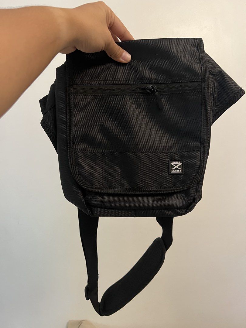 Fujifilm X Series Black Messenger Camera Bag (Category: Camera Bags & Carriers) located in Las Pinas. Submitted by csco.mnl (Listing ID 1465673934, Image 1). Description: - Brand: Fujifilm X Series - Color: Classic Black - Material: Durable, weather-ready nylon - Storage: Front zipper pocket, mesh pocket under flap, and main compartment with inner divider sleeves - Comfort: Adjustable shoulder strap with padded support - Condition: Clean inside a