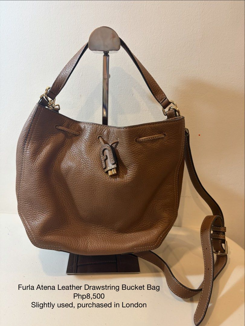Furla Atena Leather Drawstring Bucket Bag (Category: Cross-body Bags) located in Bacoor. Submitted by tin.teodosio (Listing ID 1465620177, Image 1). Description: - Authentic Furla Atena drawstring bucket bag - Crafted from premium brown pebbled leather with chic gold hardware - Features the iconic Furla arch logo charm - Versatile carry options with a top handle and adjustable shoulder strap - Roomy interior, perfect for everyday casual use - Pur