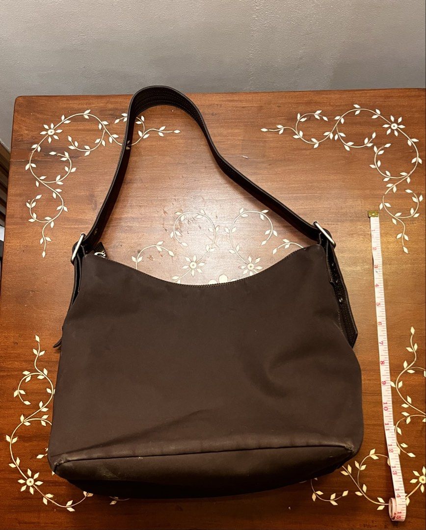 Gap Brown Hobo Nylon Bag (Category: Shoulder Bags) located in Manila. Submitted by lalalens._ (Listing ID 1465677259, Image 1). Description: fixed + SF !! stylish hobo nylon bag with adjustable strap and zipper enclosure. very spacious interior, great for everyday wear! just not my style (see last pic for try-on).
