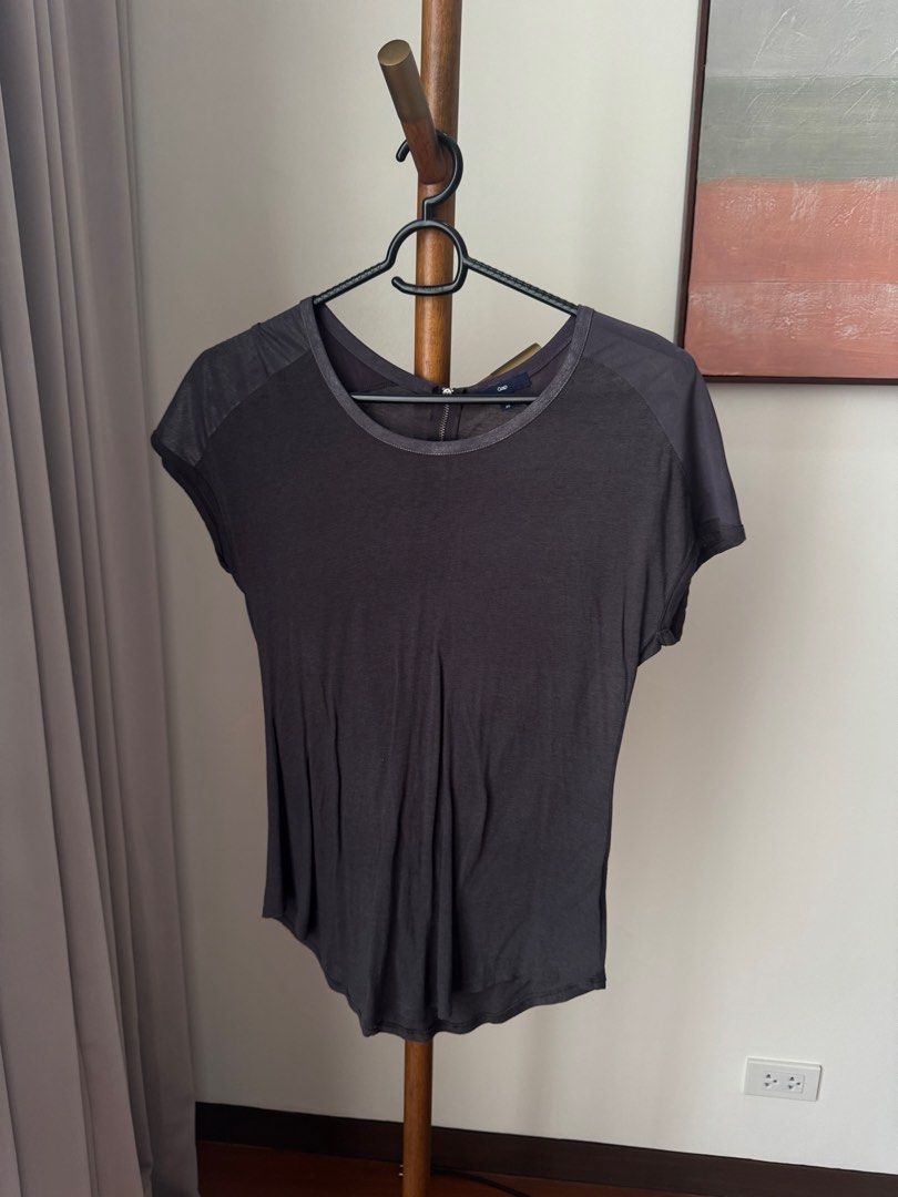 Gap Dark Grey Blouse (Category: Shirts) located in Pasig City. Submitted by kutleyn (Listing ID 1465657788, Image 1). Description: - Brand: Gap - Size: XS - Color: Dark Grey - Sleeves: Short sleeves with stylish sheer patterned panels - Neckline: Rounded neckline with a small zip closure at the back collar - Details: Slight gathering at the front hem for a flattering fit - Condition: Excellent pre-loved condition (ready to wear).