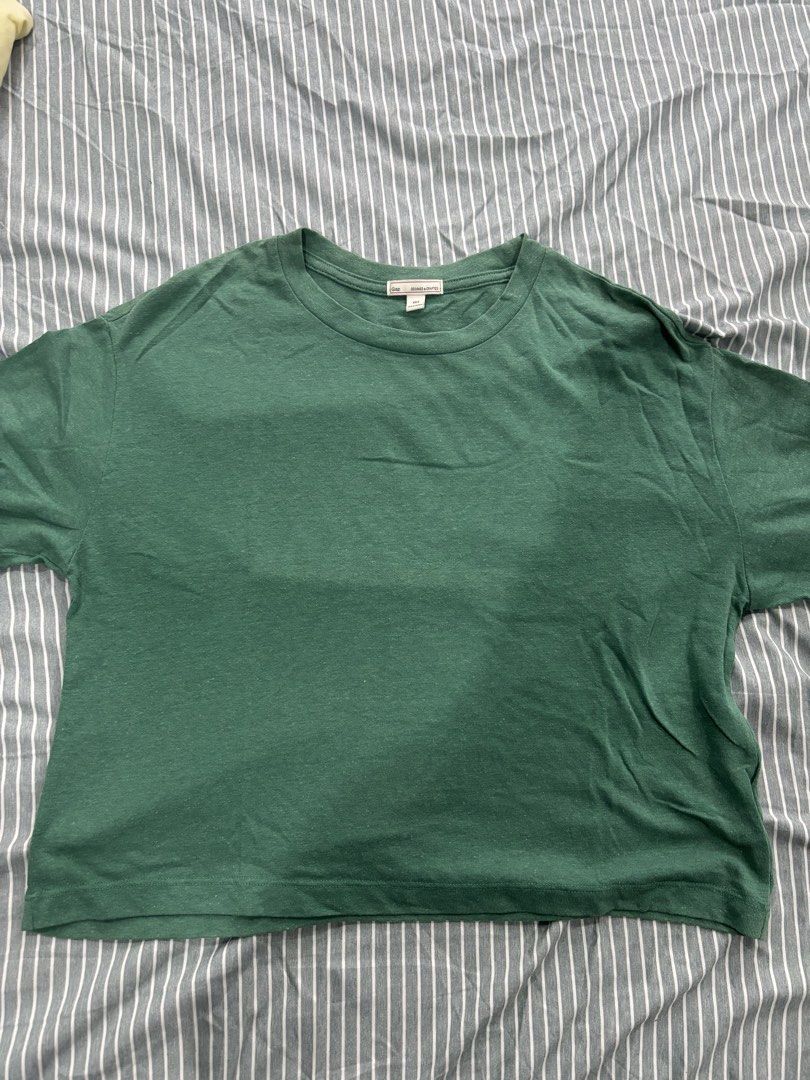 Gap Green T-Shirt (Category: Shirts) located in San Pablo. Submitted by loved.goods0501 (Listing ID 1465644970, Image 1). Description: Brand: Gap Color: Heathered dark green Size: XXS Material: Soft cotton Fit: Relaxed, boxy fit with a cropped length Neckline: Crew neck Sleeve: Short sleeve.