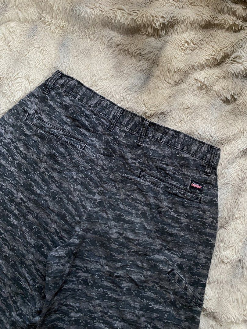 Genuine Dickies Camo Pattern Cargo Shorts Grey Black (Category: Shorts) located in Andop. Submitted by safewater-895a (Listing ID 1465677850, Image 2). Description: - Brand: Genuine Dickies - Design: Dark grey and black camouflage pattern - Closure: Classic button closure with zipper fly and belt loops - Pockets: Dual back pockets with secure button closures - Details: Signature Dickies woven logo tag on back right pocket - Style: Durable utility