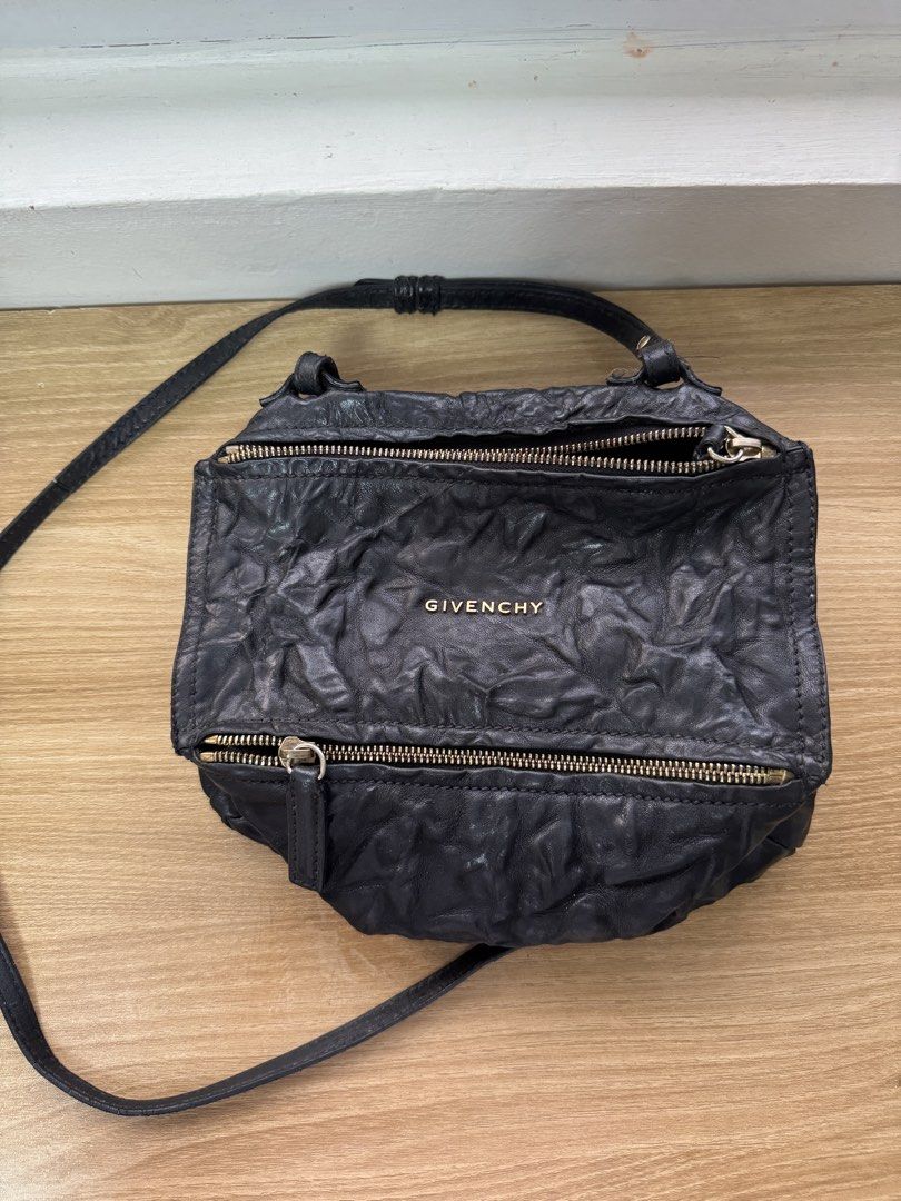 Givenchy Pandora Bag (Crossbody) Black (Category: Luxury Bags & Wallets) located in Manila. Submitted by prinsloo_ (Listing ID 1465662809, Image 2). Description: - Brand: Givenchy - Material: Black crinkled leather with subtle texture - Hardware: Gold-tone accents - Closure: Secure zip closures on front and top - Strap: Long and adjustable for comfortable wear - Pockets: Convenient exterior slip pocket on the back - Style: Slouchy, edgy, and perf