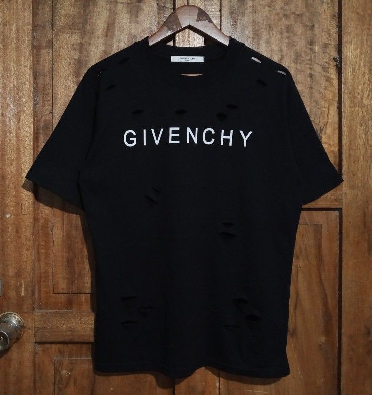 Givenchy Paris Distressed Logo T-Shirt Black (Category: Activewear) located in Boston. Submitted by johnpaulvi30029 (Listing ID 1465692481, Image 1). Description: - Brand: Givenchy Paris - Color: Black with white chest logo - Style: Short sleeve crew neck t-shirt - Details: Intentional distressed rips and cutouts around the collar and lower hem for a streetwear edge - Condition: Clean, well-maintained - Deal: Ready to ship or meet up in Metro Man