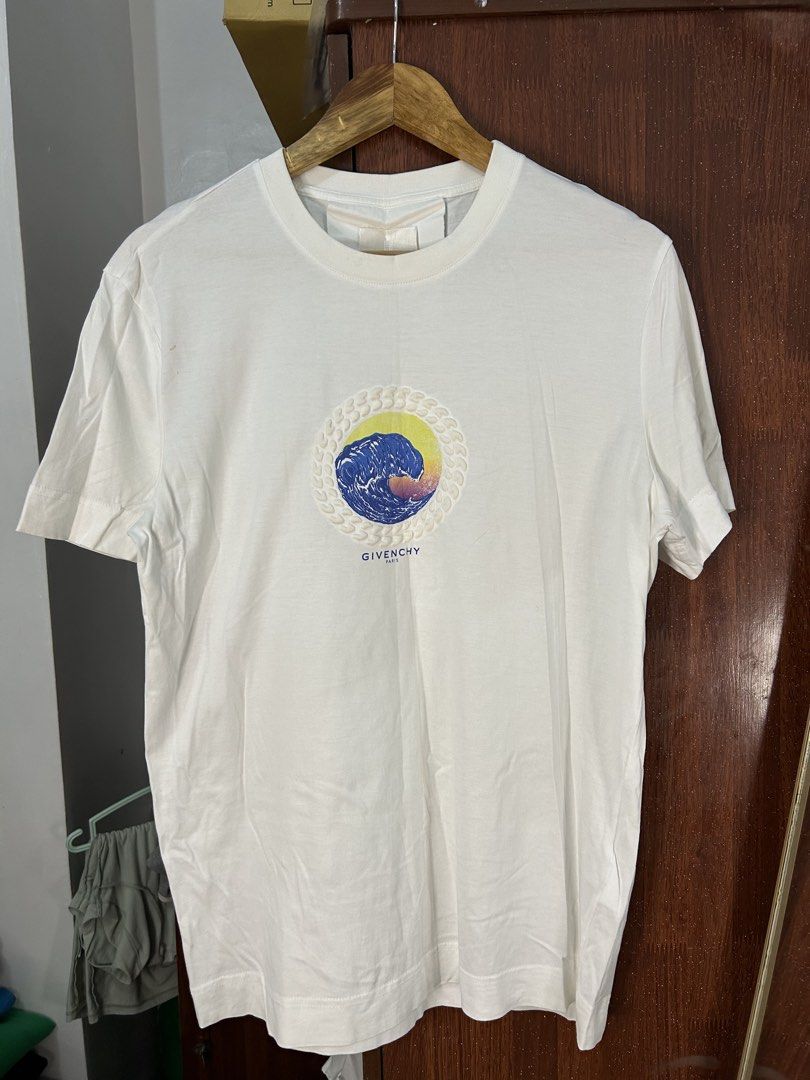Givenchy Paris Wave Graphic White T-Shirt Size M (Category: Tshirts & Polo Shirts ) located in Davao. Submitted by ruggedthrift444 (Listing ID 1465687233, Image 1). Description: - Brand: Givenchy Paris - Size: M - Color: Clean White - Design: Colorful wave graphic inside a textured circular frame on the front - Details: Small branding print near the bottom hem on the back - Material: 100% premium cotton - Fit: Classic crew neckline with short sle