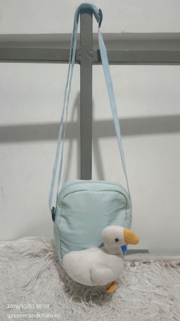 GOOSE KIDDIE LIGHT BLUE CROSS BODY BAG (Category: Cross-body Bags) located in Kalibo. Submitted by secondchances.thriftsh8p (Listing ID 1465690915, Image 1). Description: - Color: Light blue - Material: Durable fabric - Cute attached white duck plushie with orange beak and feet - Adjustable light blue shoulder strap with side-release buckle - Secure top zip closure - Compact size, perfect for everyday essentials - Brand new and ready to ship!.