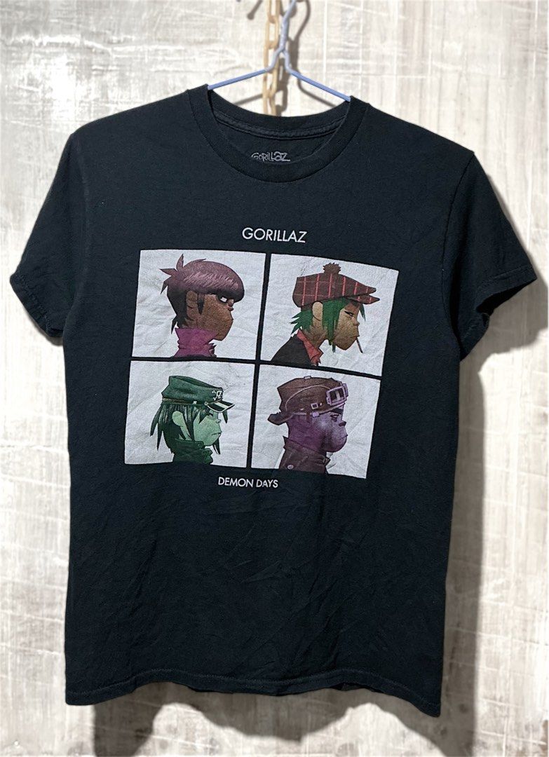 Gorillaz Demon Days Graphic Tee Black Size S (Category: Tshirts & Polo Shirts ) located in Naga. Submitted by lootersfinder (Listing ID 1465619403, Image 1). Description: - Authentic Gorillaz Demon Days merchandise - Color: Black - Size: Small (100% Cotton, Made in Dominican Republic) - Features iconic album art and 4 character portraits on the front - Condition: Minor fading around the neckline from washing and regular wear.