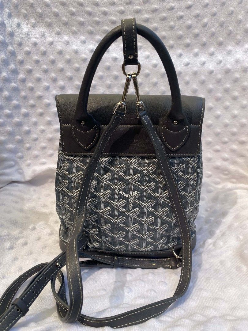 Goyard Alpin Mini Backpack (Category: Backpacks) located in Tanay. Submitted by micvalcorza (Listing ID 1465738088, Image 2). Description: - Alpin Mini grey Goyard coated canvas and leather backpack - Iconic signature chevron print throughout - Secure flap top closure with metal buckle and drawstring - Comfortable adjustable leather shoulder straps and top grab handle - Premium silver-tone hardware stamped with Goyard - Debossed logo detail near 