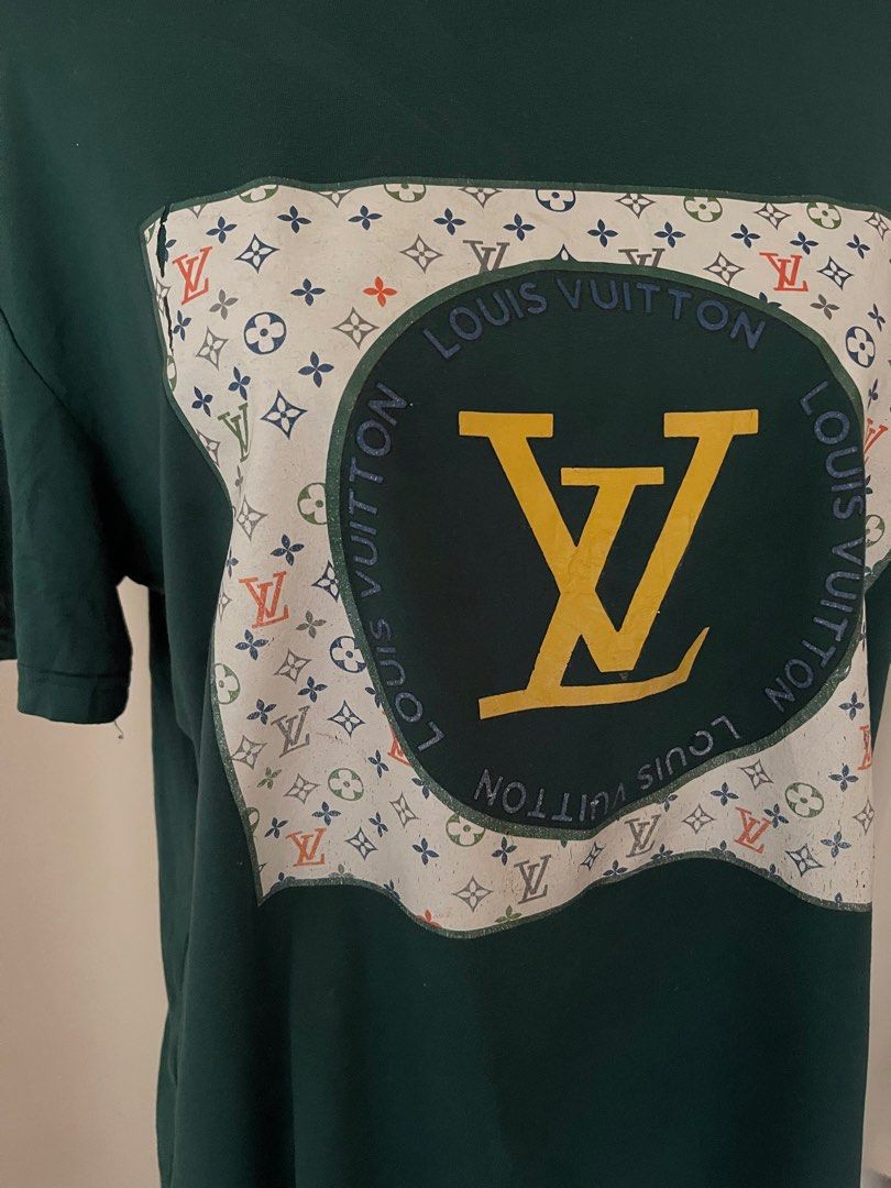 Green Graphic Print T-Shirt (Category: Tshirts & Polo Shirts ) located in Cainta. Submitted by zlove111 (Listing ID 1465583969, Image 2). Description: - Color: Dark green - Fit: Relaxed fit with short sleeves and crew neck up to xl 22" - Material: Soft, comfortable cotton - Design: Eye-catching large chest patch featuring a multicoloured monogram, circular lettering, and a bold yellow LV logo - Style: Perfect for casual everyday wear.