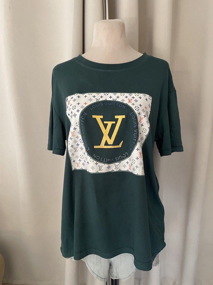 Green Graphic Print T-Shirt (Category: Tshirts & Polo Shirts ) located in Cainta. Submitted by zlove111 (Listing ID 1465583969, Image 1). Description: - Color: Dark green - Fit: Relaxed fit with short sleeves and crew neck up to xl 22" - Material: Soft, comfortable cotton - Design: Eye-catching large chest patch featuring a multicoloured monogram, circular lettering, and a bold yellow LV logo - Style: Perfect for casual everyday wear.