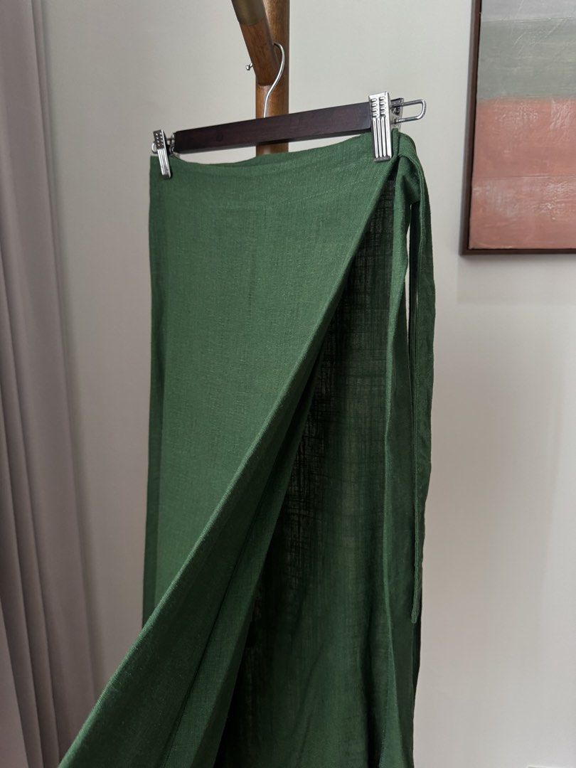 Green Wrap Skirt Linen Midi (Category: Skirts) located in Pasig City. Submitted by kutleyn (Listing ID 1465697220, Image 2). Description: - Color: Rich forest green - Style: Classic wrap midi skirt with adjustable side tie closure - Fabric: Lightweight material with a beautiful drape - Perfect for: Warm weather, casual outings, and everyday wear - Versatility: Easy to pair with basic tees or chic blouses.
