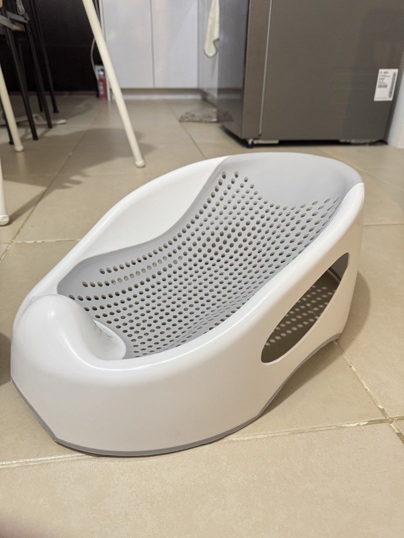 Grey Baby Bath Bed Support Seat (Category: Bathtub & Bath Accessories) located in Pasay City. Submitted by decluttering_mom_2026 (Listing ID 1465674715, Image 3). Description: - Ergonomic grey and white design supports newborns safely during bath time - Perforated mesh base ensures quick and easy water drainage - Non-slip features keep your baby secure while bathing - Lightweight plastic material is simple to rinse and clean after use - A must-ha