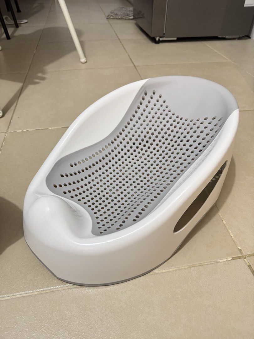 Grey Baby Bath Bed Support Seat (Category: Bathtub & Bath Accessories) located in Pasay City. Submitted by decluttering_mom_2026 (Listing ID 1465674715, Image 1). Description: - Ergonomic grey and white design supports newborns safely during bath time - Perforated mesh base ensures quick and easy water drainage - Non-slip features keep your baby secure while bathing - Lightweight plastic material is simple to rinse and clean after use - A must-ha