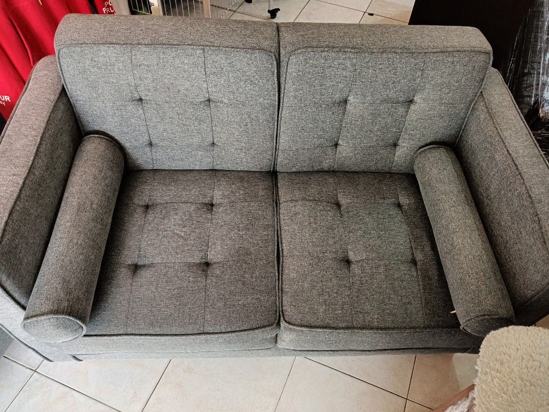 Grey Fabric Sofa Mandaue Foam (Category: Sofas) located in Las Pinas. Submitted by jenny.nogu (Listing ID 1465702642, Image 3). Description: - Mandaue Foam Sofa - No lubog, no lundo, no punit - Style: Modern grey fabric sofa with a chic tufted back - Comfort: Includes two matching bolster pillows for extra support and style - Durability: Supported by sturdy wooden legs underneath - Versatility: Neutral color effortlessly matches any home interior