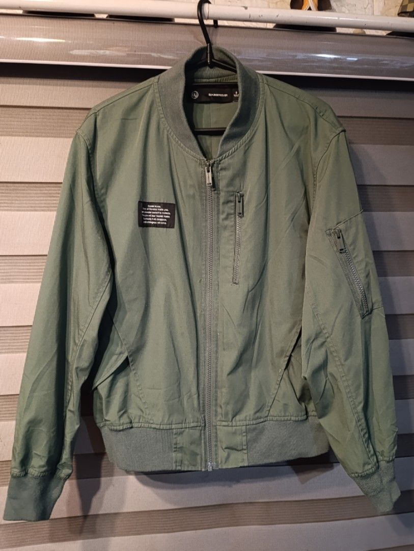 GU x UNDERCOVER Bomber Jacket Olive Green Size S (Category: Coats, Jackets and Outerwear) located in Manila. Submitted by yunicool (Listing ID 1465593643, Image 2). Description: - Brand: GU x UNDERCOVER - Item: Olive green bomber jacket - Size: S - Details: Full zip front, sleeve zip pocket, and vertical chest pocket - Design: Woven 'Kosmik Noise. Erase all the noise inside you...' patch on right chest - Finishing: Ribbed collar, cuffs, and hem -