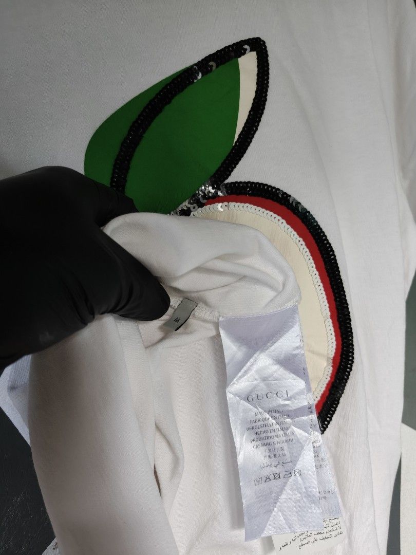 Gucci Apple Sequins White T-Shirt Size M (Category: Shirts) located in Manila. Submitted by choycleverdeer.f04b80 (Listing ID 1465632806, Image 3). Description: - Authentic Gucci white cotton t-shirt - Eye-catching large sequin apple graphic on the front with Double G logo - Classic crew neckline and short sleeves - Size: M (tag attached near the collar) - Includes Gucci neck label and Made in Italy tag - Pristine white fabric with all sequin det