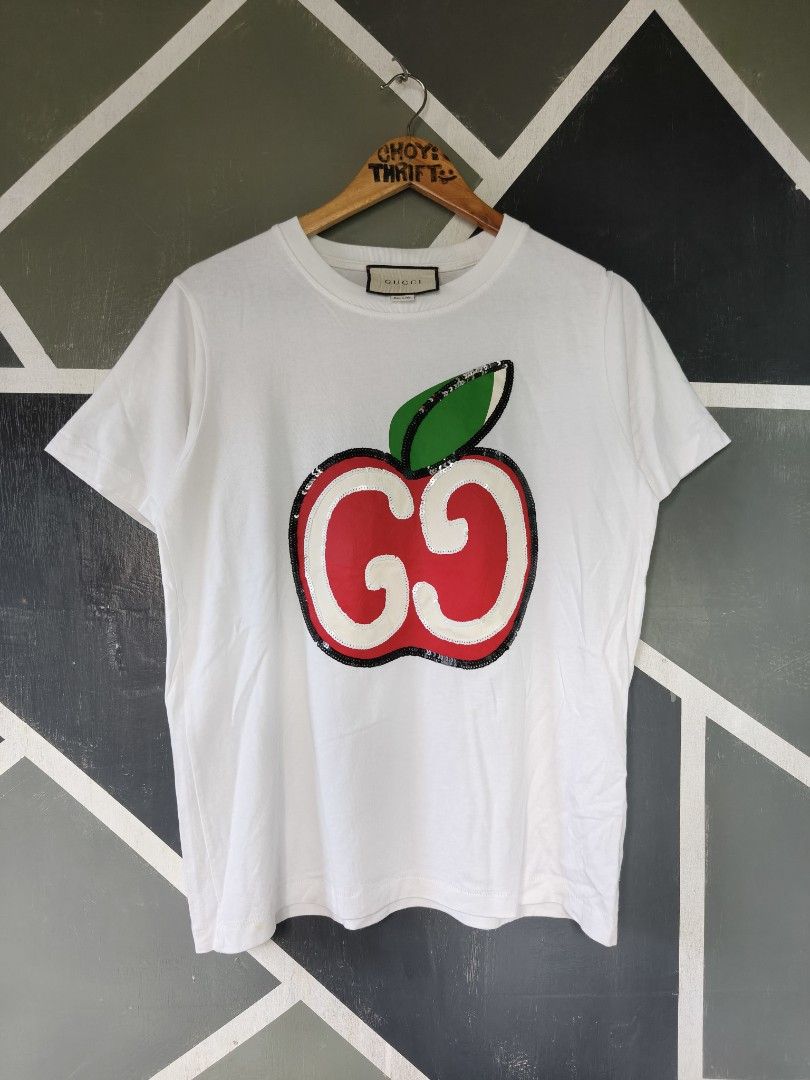 Gucci Apple Sequins White T-Shirt Size M (Category: Shirts) located in Manila. Submitted by choycleverdeer.f04b80 (Listing ID 1465632806, Image 1). Description: - Authentic Gucci white cotton t-shirt - Eye-catching large sequin apple graphic on the front with Double G logo - Classic crew neckline and short sleeves - Size: M (tag attached near the collar) - Includes Gucci neck label and Made in Italy tag - Pristine white fabric with all sequin det