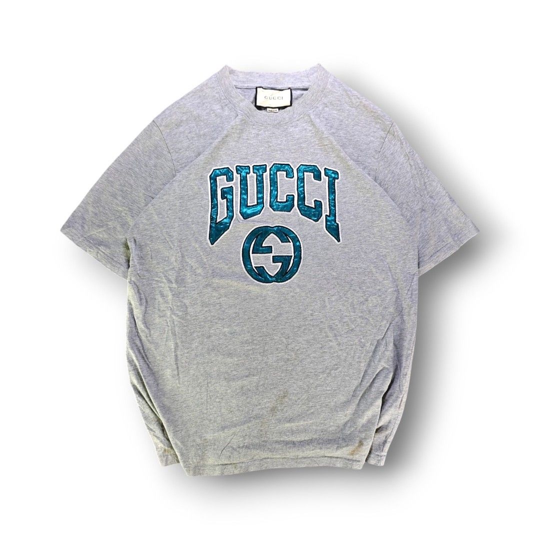 Gucci Arch Logo Light Gray Tee (Category: Tshirts & Polo Shirts ) located in San Pedro. Submitted by chronothrift (Listing ID 1465652644, Image 1). Description: - Size: Large - XL (W21.5 x 29L) - Condition: 9/10 - Color Rate: 9/10 - Flaws: Stains (Needs Wash) MOD: J&T Express / Lalamove / Meet MOP: Gcash / Bank Transfer.