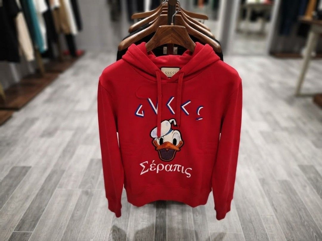 Gucci x Disney Distressed (Category: Others Tops) located in Iba. Submitted by selector_items (Listing ID 1465642042, Image 1). Description: *Gucci x Disney "Distressed" Donald Duck Hoodie* from the 2020 Pre-Fall Collection 🔥 ### *What makes it "distressed":* 1. *Design intent* - Gucci intentionally made this with a worn/vintage effect. That slight fraying near the hood drawstring and the textured chenille patch are part of the look. 2. *Chenill