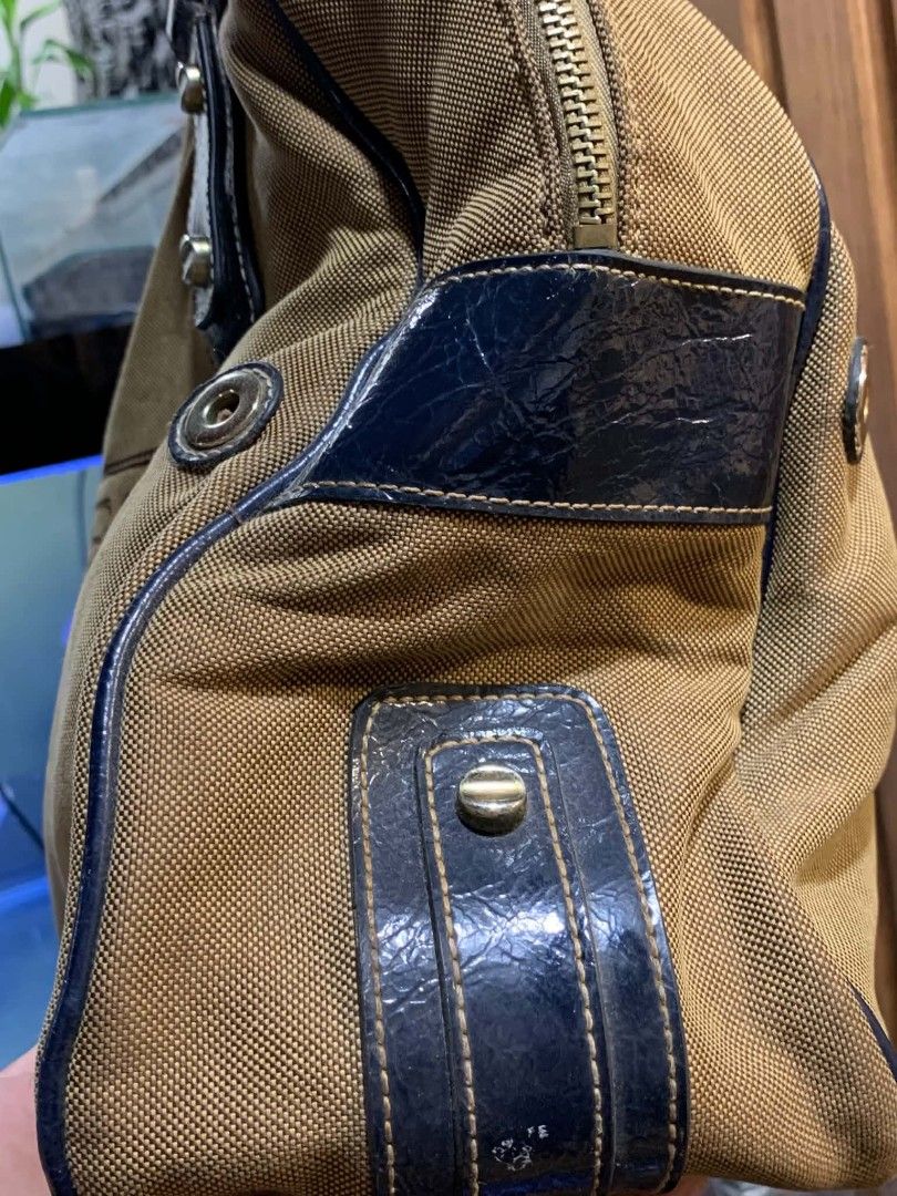 Guess Khaki and Blue Canvas Handbag (Category: Shoulder Bags) located in Manila. Submitted by kylie_jenner. (Listing ID 1465660609, Image 3). Description: - Brand: Guess - Material: Khaki canvas with blue patent leather trim - Design: Large Guess USA logo on front, silver-tone 'G' charm and padlock pendant - Handles: Double shoulder handles with metallic rivet details - Closure: Zip top closure - Condition: Clean interior and bottom base - Usage: