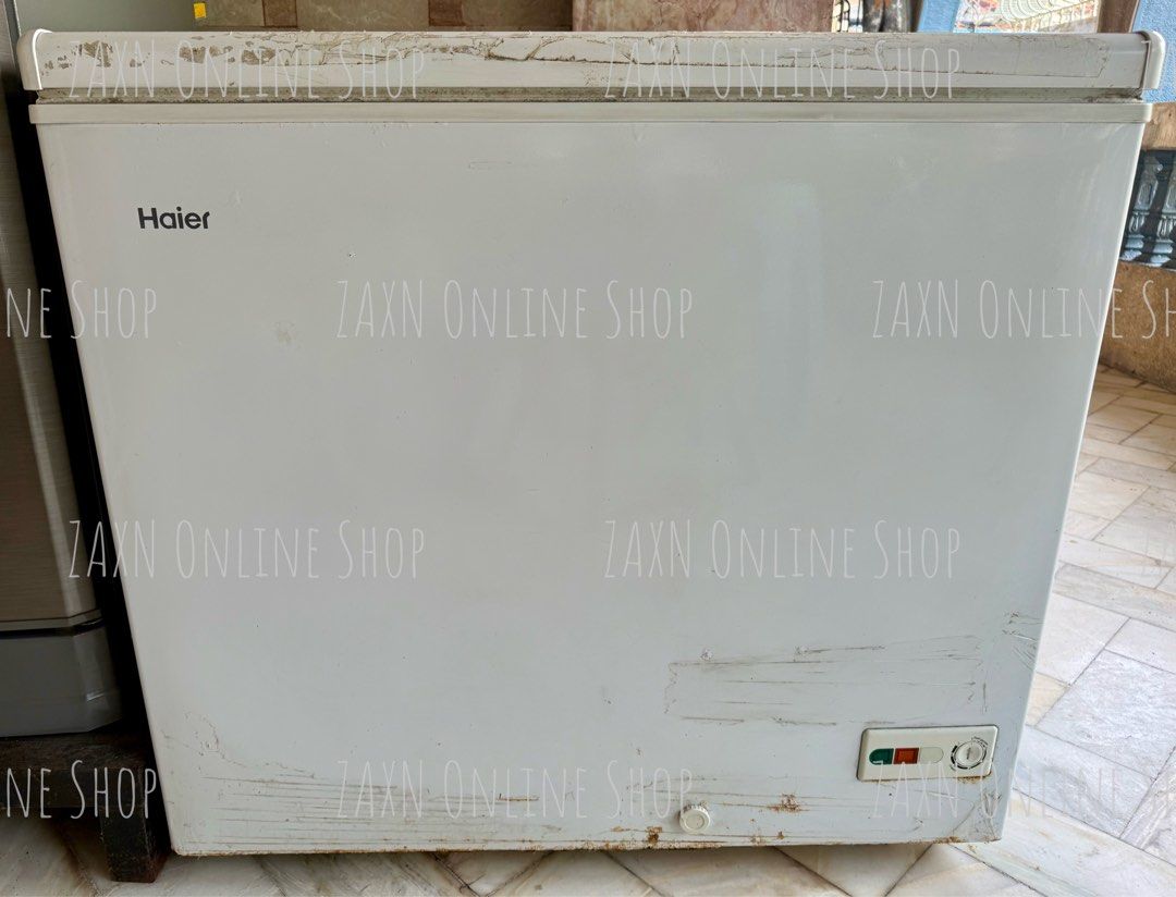 Haier White Chest Freezer (Category: Refrigerators and Freezers) located in Santa Cruz. Submitted by za2011za (Listing ID 1465581912, Image 2). Description: - Brand: Haier chest freezer - Color: White - Features: Top-opening lid with built-in lock, interior wire storage basket, and front control panel with power indicator - Condition: Cools well; exterior shows a bit scratches, scuffs, and paint wear around the edges near the lid seal due to stor