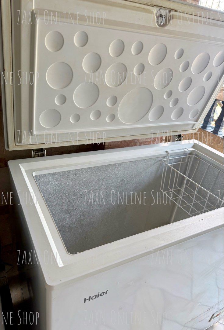 Haier White Chest Freezer (Category: Refrigerators and Freezers) located in Santa Cruz. Submitted by za2011za (Listing ID 1465581912, Image 1). Description: - Brand: Haier chest freezer - Color: White - Features: Top-opening lid with built-in lock, interior wire storage basket, and front control panel with power indicator - Condition: Cools well; exterior shows a bit scratches, scuffs, and paint wear around the edges near the lid seal due to stor