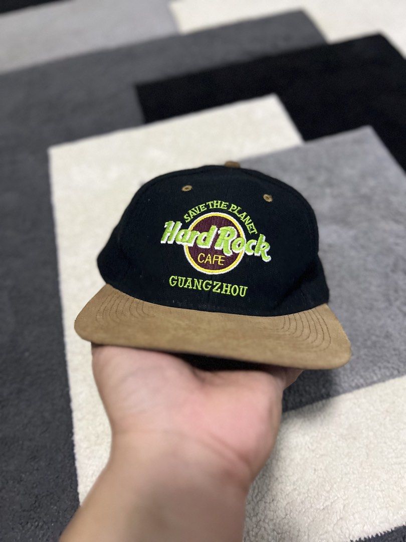 Hard Rock Cafe Guangzhou Save The Planet Cap (Category: Caps & Hats) located in Calasiao. Submitted by pb.supply_v2 (Listing ID 1465752640, Image 1). Description: - Brand: Hard Rock Cafe Guangzhou - Design: Black body with a contrasting brown brim - Embroidery: 'Save The Planet' and 'Guangzhou' on the front; 'Love All Serve All' in yellow on the back - Fit: Adjustable plastic snap closure - Condition: Excellent, ready to wear.