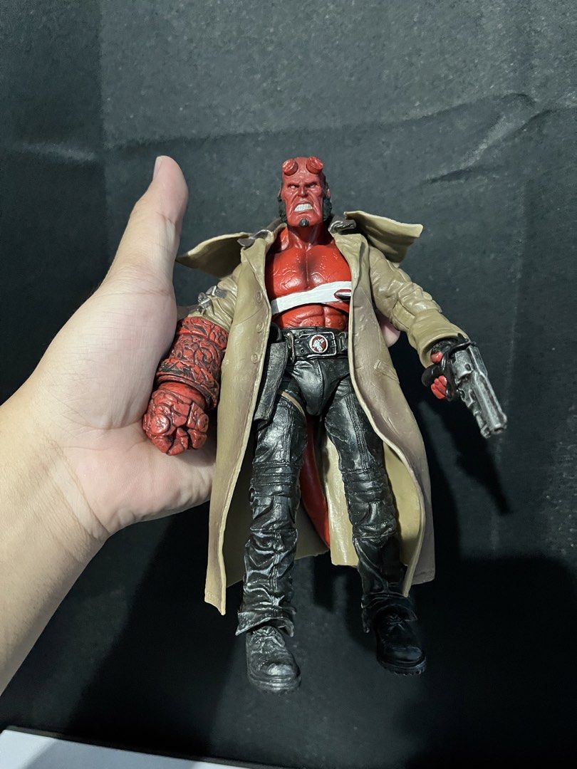 Hellboy Action Figure with Trench Coat and Gun (Category: Figurines & Statues) located in Cabanatuan. Submitted by isaiahave (Listing ID 1465678801, Image 1). Description: - Detailed Hellboy action figure holding his signature Samaritan gun - Features the iconic Right Hand of Doom and a classic tan trench coat - Accurately sculpted with black pants, textured boots, and visible red tail at the back - Stands upright firmly, perfect for display - Gr