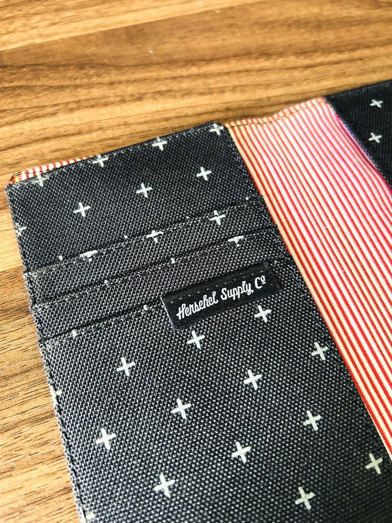 Herschel Supply Co. | Raynor RFID Passport Holder Cross Pattern (Category: Luxury Bags & Wallets) located in Makati City. Submitted by reese.stone (Listing ID 1465632673, Image 3). Description: - Herschel passport holder in dark grey with a white cross pattern all over. - Classic red and white striped interior lining. - Multiple card slots on the left side and slip pockets for passport storage. - Herschel logo tag on the front exterior and inside