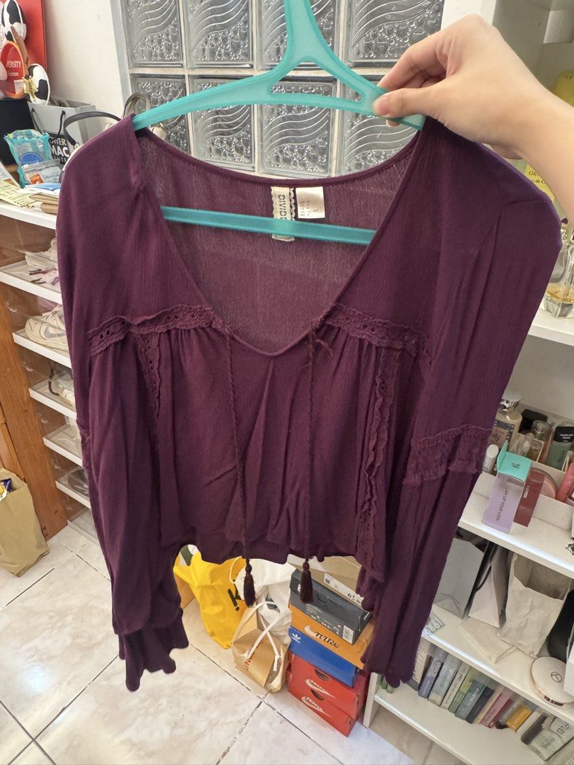 H&M Divided Purple Long Sleeve Blouse (Category: Longsleeves) located in Manila. Submitted by klaaarrr (Listing ID 1465728910, Image 1). Description: - Brand: H&M Divided - Color: Deep purple - Style: V-neck with front tie tassels and relaxed fit - Details: Delicate lace trim on the chest and long sleeves with ruffled cuffs - Fabric: Lightweight, crinkled material - Length: Cropped.