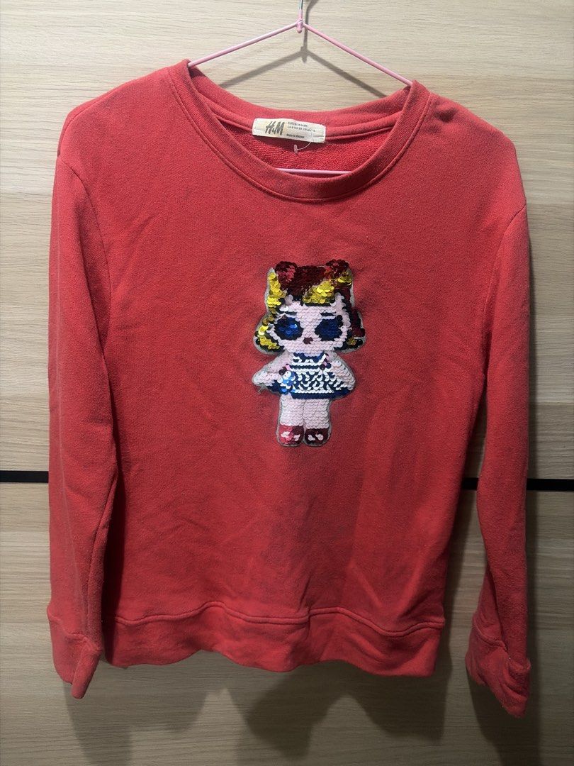 H&M Red Sequined Doll Sweatshirt Size 9-10Y (Category: Babies & Kids Fashion) located in Cainta. Submitted by sarisari_online2020 (Listing ID 1465713173, Image 1). Description: - Brand: H&M - Color: Red - Size: EUR 130 / US 9-10Y - Design: Fun reversible sequin doll graphic on the front - Features: Round neckline, ribbed cuffs, cozy cotton material - Condition: Normal wash wear on fabric, graphics are fully intact - Perfect for: Everyday casual w