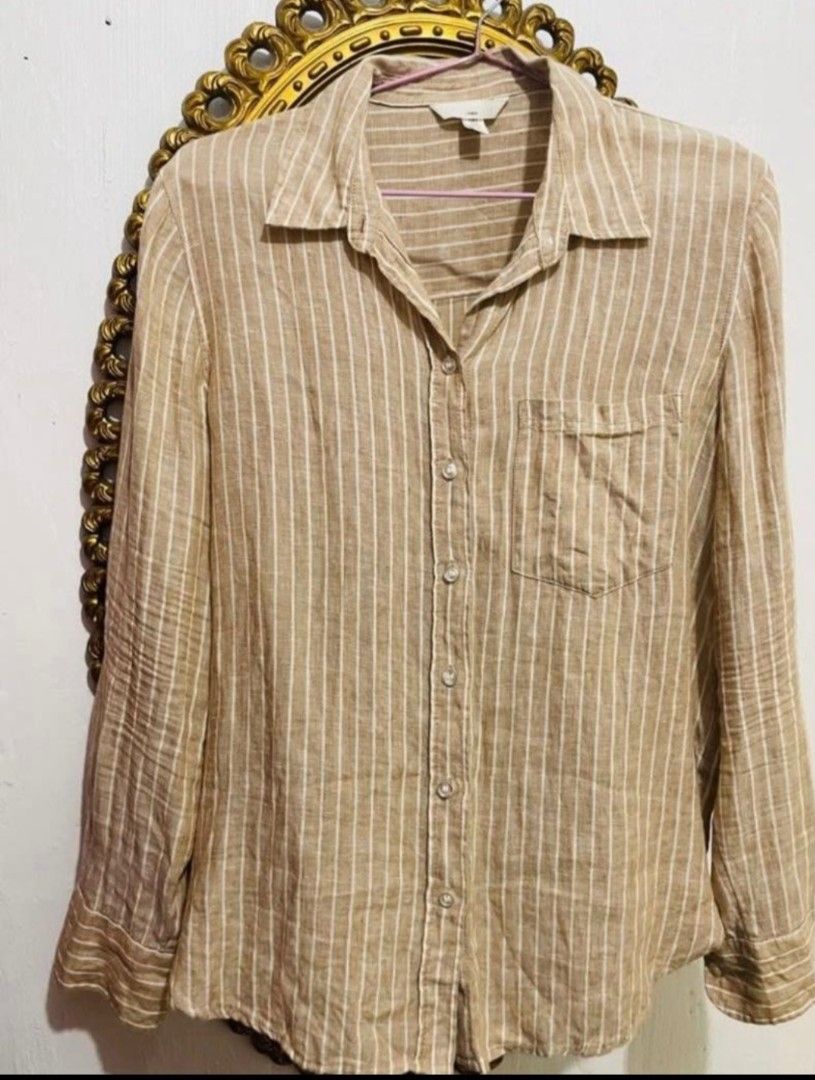 H&M Striped Linen Shirt Size S (Category: Shirts) located in San Juan City. Submitted by marie_d_r (Listing ID 1465685034, Image 2). Description: - Brand: H&M - Color: Neutral brown with white vertical stripes - Size: S - Material: Lightweight, breathable linen fabric - Features: Long sleeves, button-up front, standard collar, single chest pocket - Condition: Excellent / Well-maintained - Perfect for: Casual wear, layering, or warm weather.