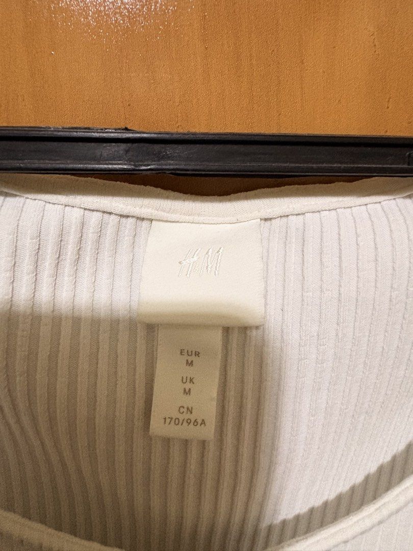 H&M White Ribbed Button-Up Short Sleeve Top (Category: Shirts) located in Mandaue City. Submitted by klosetfindscebu (Listing ID 1465661007, Image 2). Description: - Brand: H&M - Size: M - Color: White - Material: Stretchy knit - Details: Short sleeves, scoop neckline with small decorative buttons, lettuce hem - Condition: Good, perfect everyday basic piece.