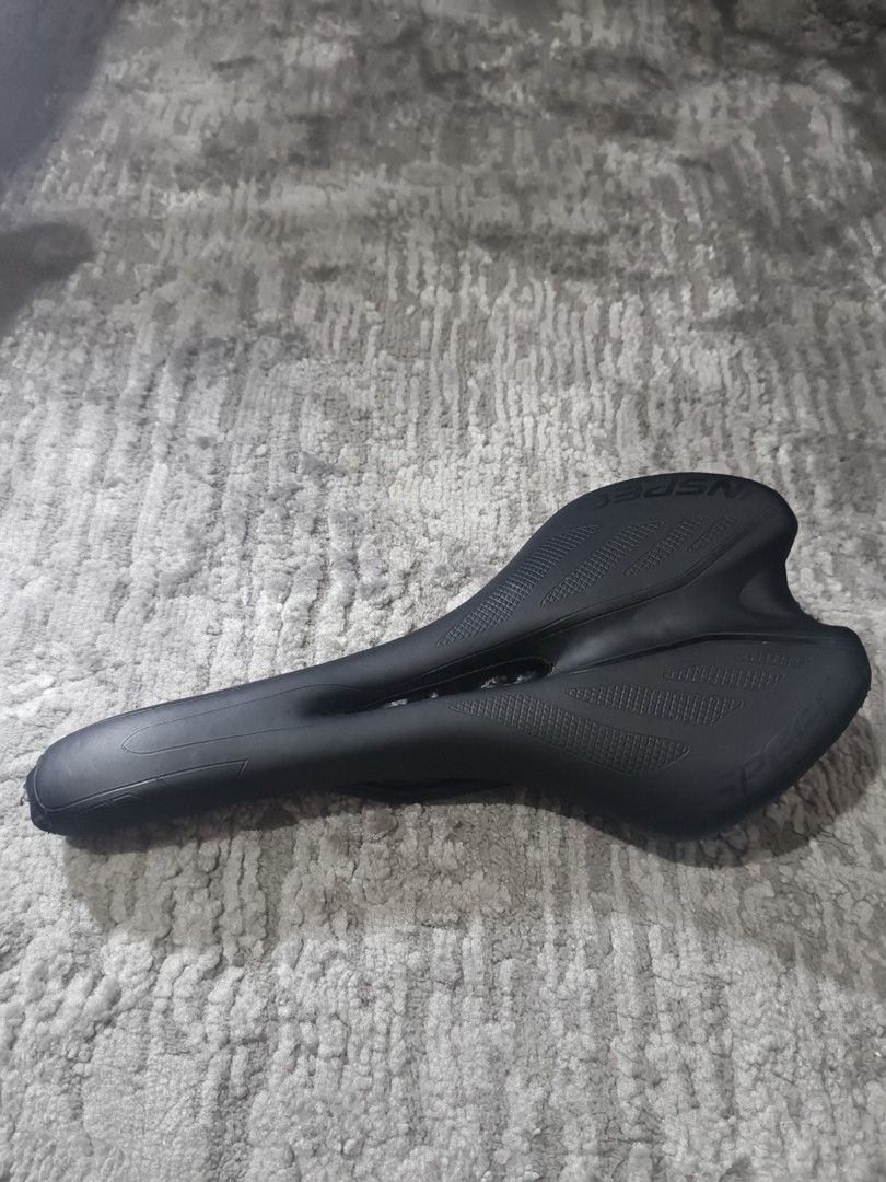 Inspeed Bicycle Saddle Black Ergonomic Seat (Category: Bicycles) located in Manila. Submitted by p2c.teal (Listing ID 1465669955, Image 3). Description: - Brand: Inspeed - Color: Black - Design: Ergonomic with center cutout channel for pressure relief - Features: Textured grip patterns on wings to prevent sliding - Compatibility: Fits road bikes and mountain bikes - Mount: Standard rail mount underneath.